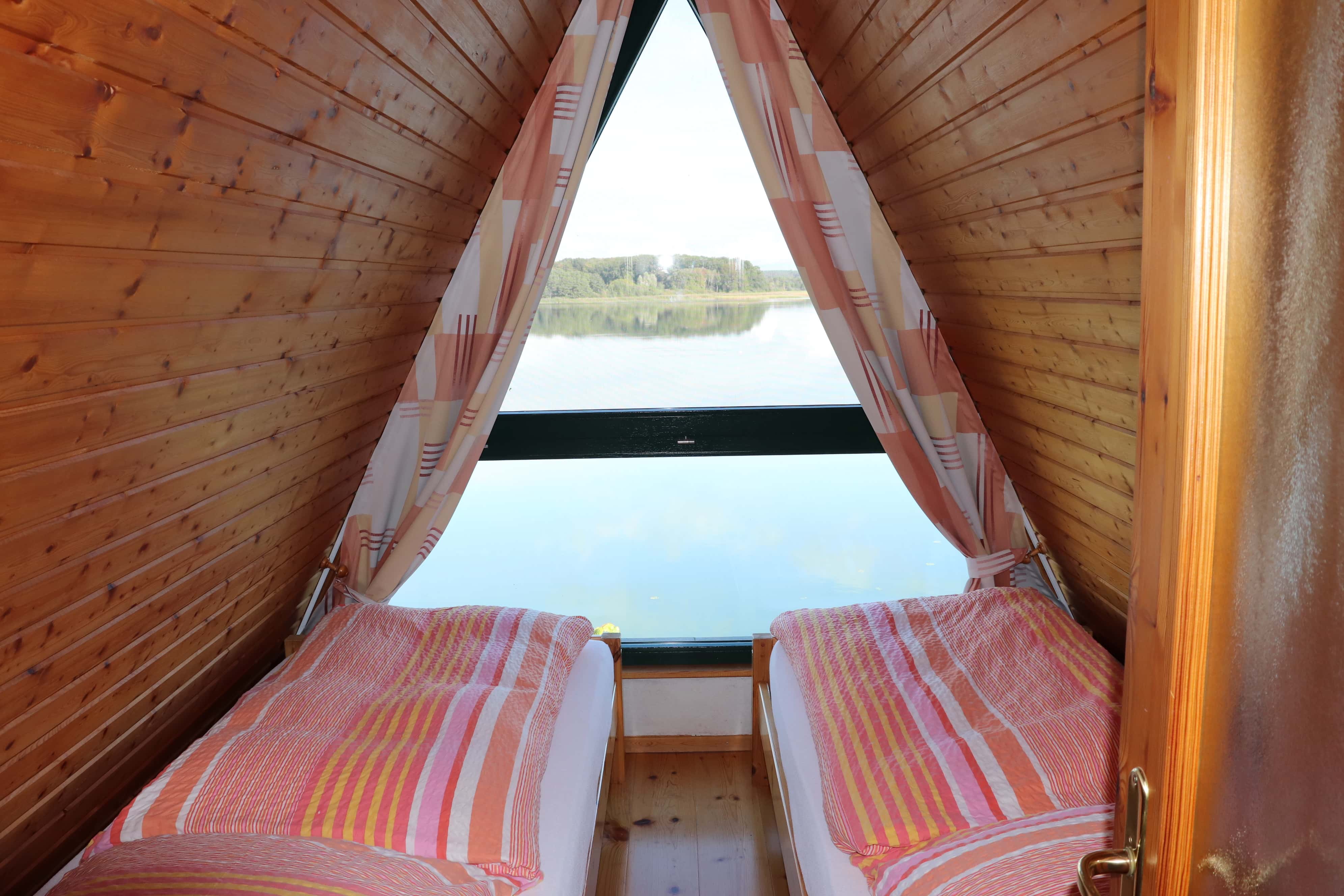 Schlafzimmer mit zwei getrennten Betten für jeweils einen Feriengast und wundervollem Ausblick auf den Sternberger See